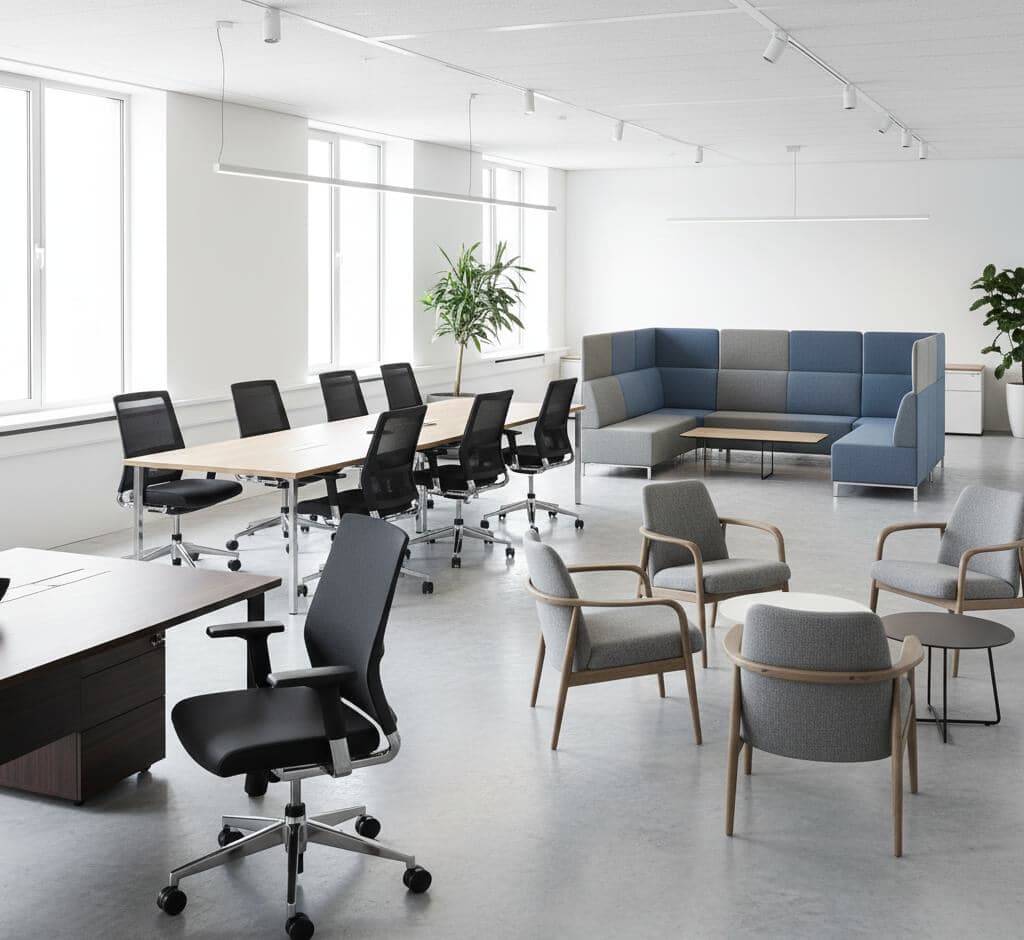 Modern corporate office space with ergonomic chairs, meeting tables, and lounge seating, perfect for professional work environments.